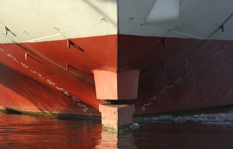 Red boat in river against built structure