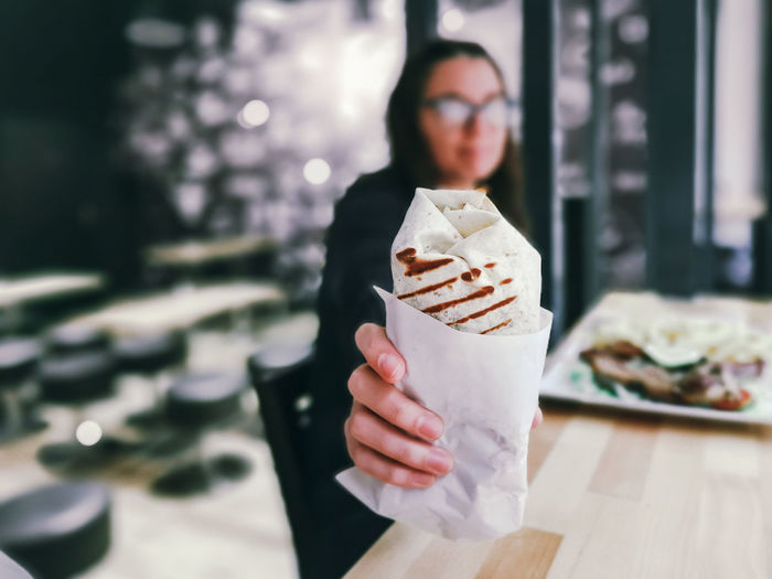 Woman giving wrap sandwich