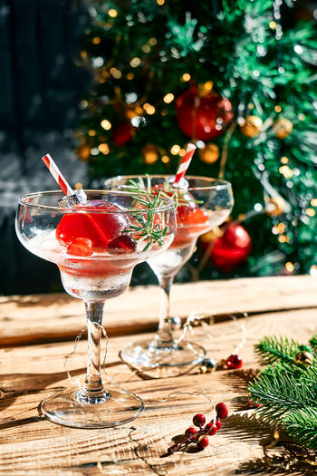 Christmas drink mimosa, punch or cranberry margarita cocktail serving in christmas ornaments