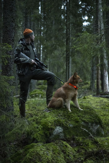 Hunter with dog in forest