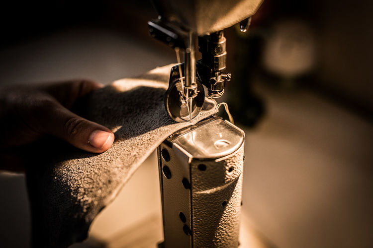Close-up of person working at sewing machine