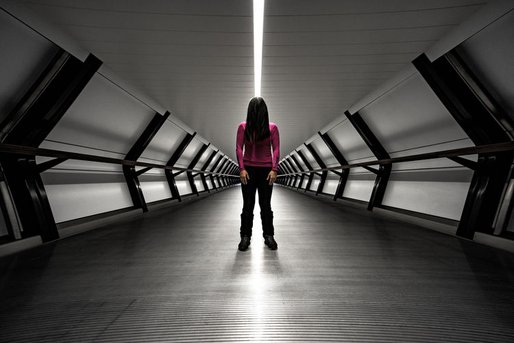 Woman standing in illuminated tunnel