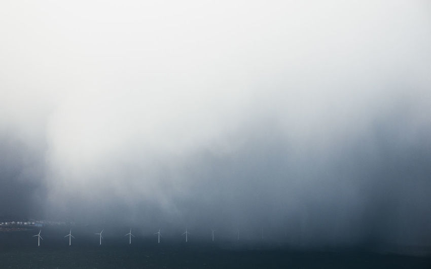 Wind mill against sky during foggy weather