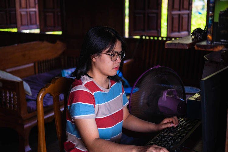 Mid adult woman using computer at home