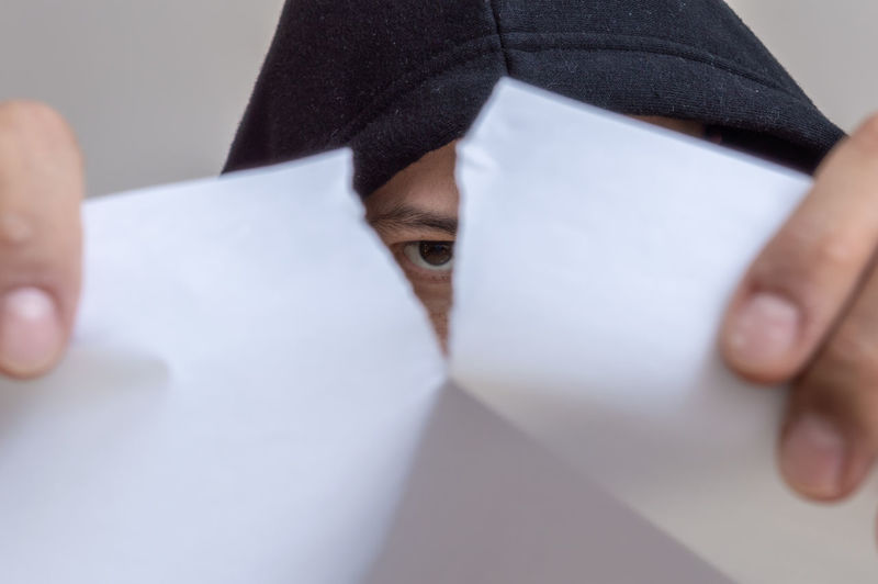 Cropped image of person tearing paper