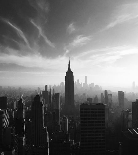 View of manhattan cityscape against cloudy sky