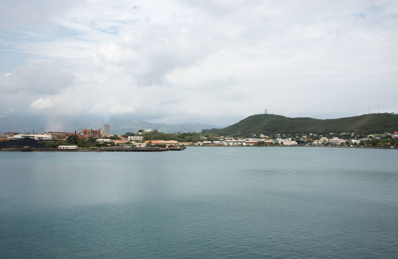 Sea by cityscape against sky