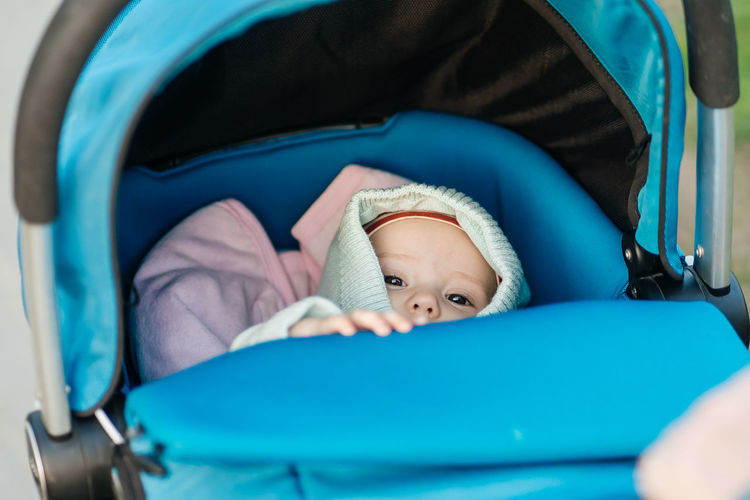 Baby in a blue stroller looks at the world around