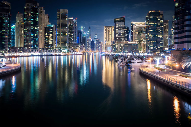 Illuminated dubai marina with reflection in marina at night