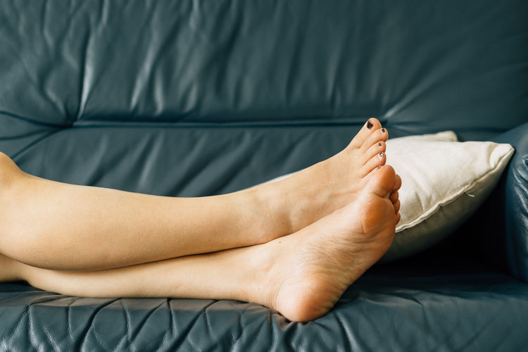Low section of woman relaxing on sofa