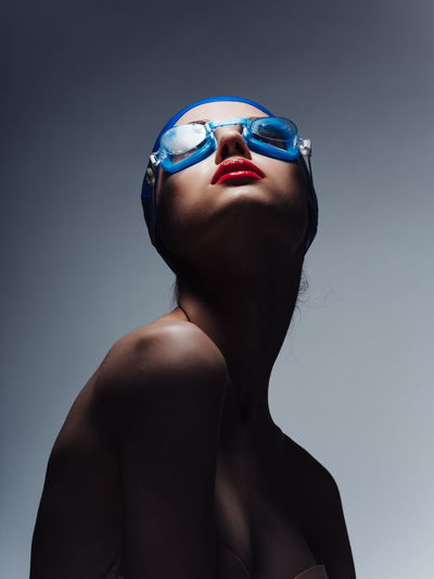 Portrait of young woman against blue background