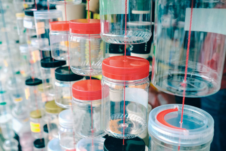 Suspended plastic containers on display in a  shop