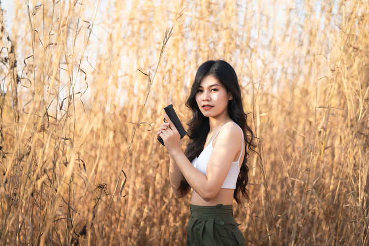 Portrait of a beautiful young woman standing in field