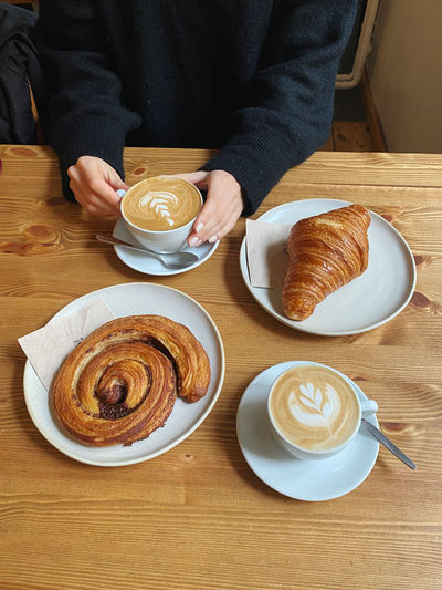 Midsection of woman having breakfast on table