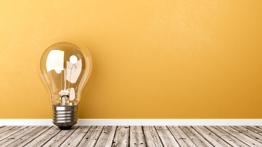 Close-up of illuminated light bulb on wall