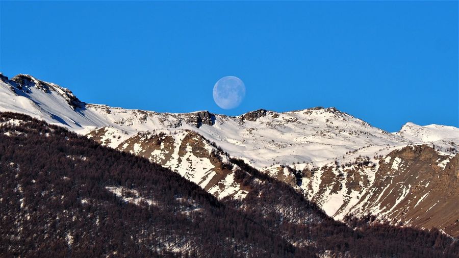 Moon setting behind the mountain in the early morning