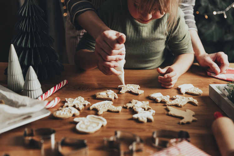Christmas and new year food preparation. gingerbread cooking decorating cookies with icing, mastic