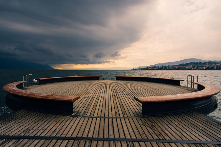 Pier over sea against sky at sunset