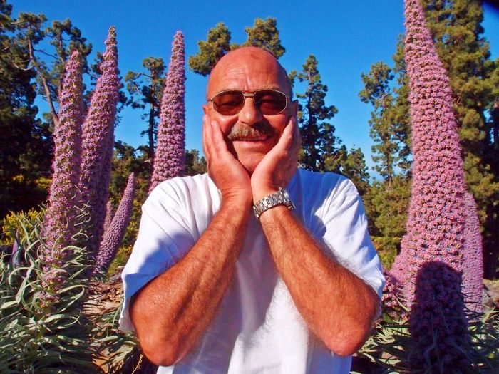 Portrait of smiling man standing against plants
