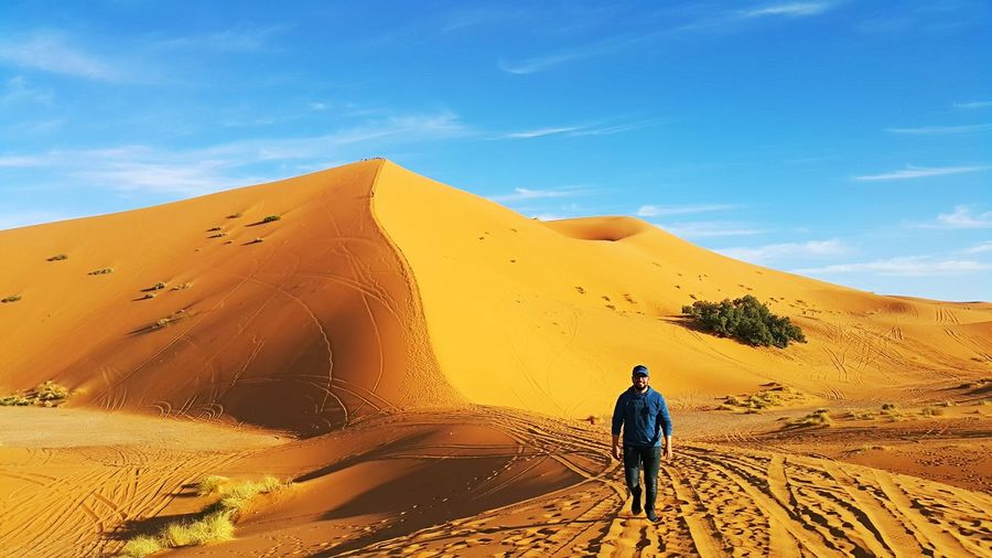Scenic view man walking in desert
