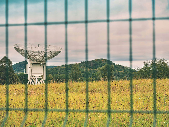 Satellite transmission antenna, large remote communication device in meadow.