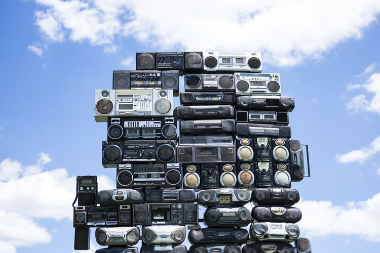 Stack of old-fashioned portable stereos against sky