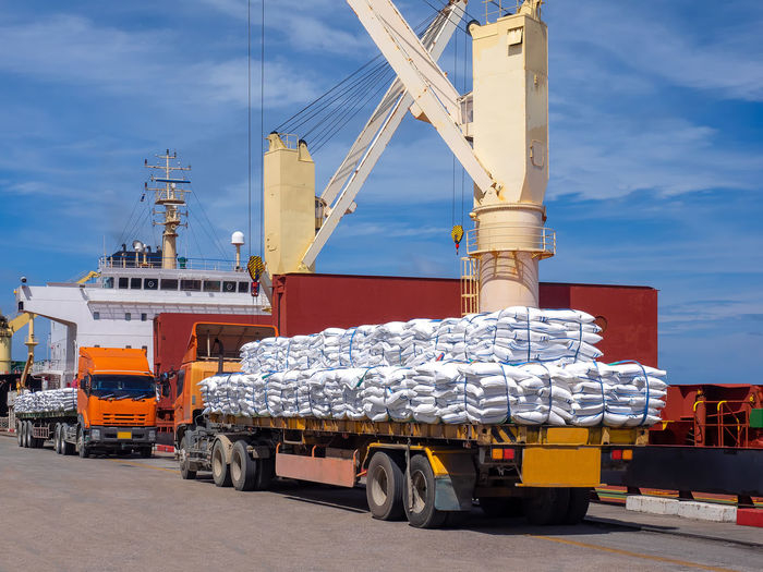 Sugar bags are loading in hold of bulk-vessel at industrial port.