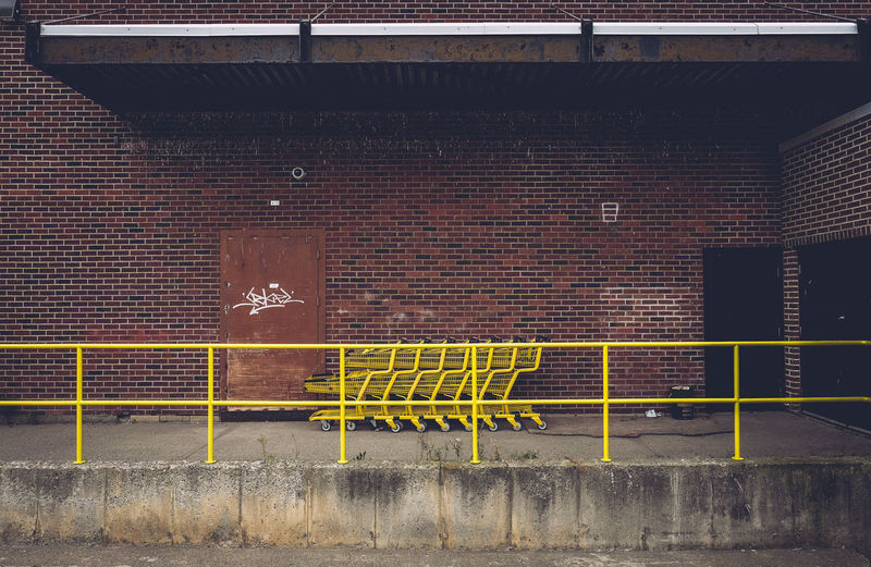 Yellow shopping carts against red brick wall