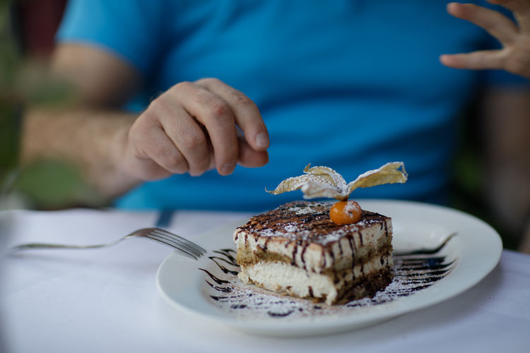 Midsection of men having dessert at table