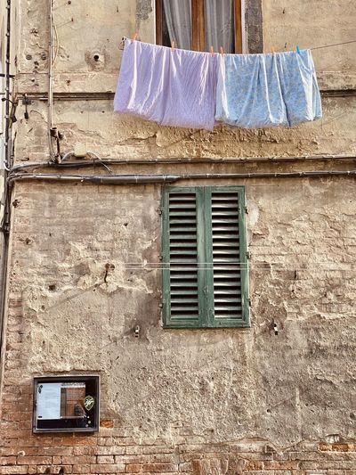 Low angle view of clothes hanging on wall of building