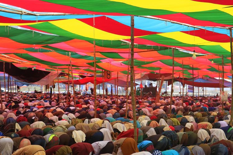 Group of people under colourful roof for prayer 