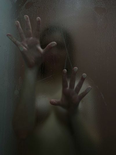 Woman hand touching glass window