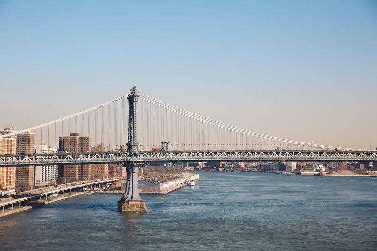 Manhattan bridge over east river against clear sky in city