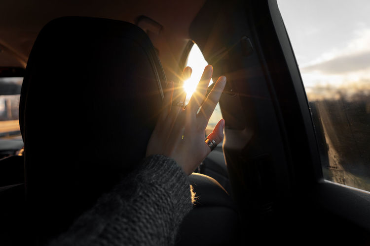 Close-up of woman hand stopping sunlight in car