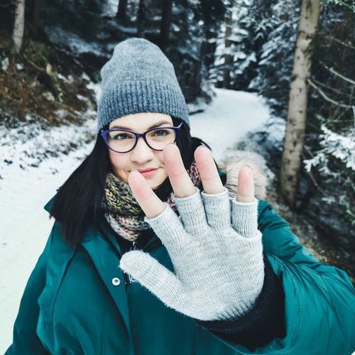 Portrait of young woman standing in snow