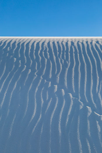 Ripples in the sand dunes at white sands national monument, new mexico, with a clear blue sky above