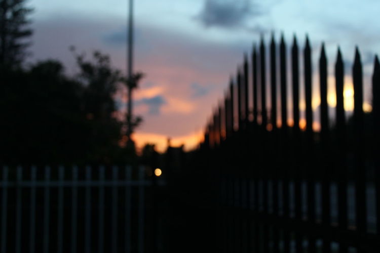 View of fence at sunset