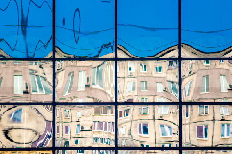 Low angle view of buildings seen through glass window