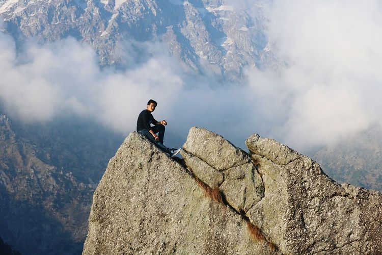 Full length of man sitting on mountain at mcleod ganj