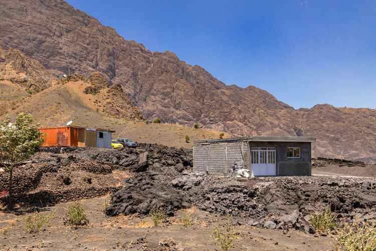 Improvised hut and containers after 2014 volcanic eruption with destroyed houses on fogo, cape verde
