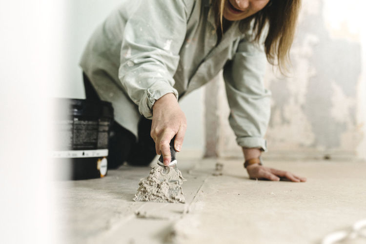Woman putting cement on floor
