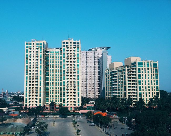 Buildings in city against blue sky