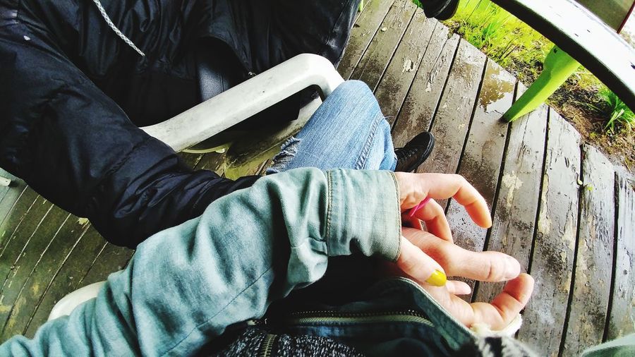 Cropped image of couple holding hands while sitting in porch