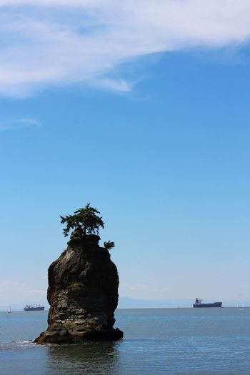 Rock formation in sea against sky