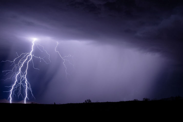 Lightning strikes illuminate a monsoon thunderstorm dropping heavy rain near gila bend, arizona.