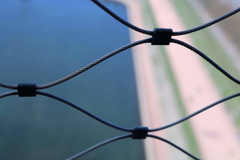 Close-up of barbed wire on chainlink fence