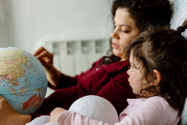 Mother and daughter playing with earth globe
