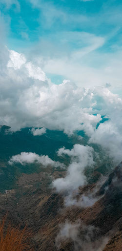 Low angle view of clouds over mountain against sky