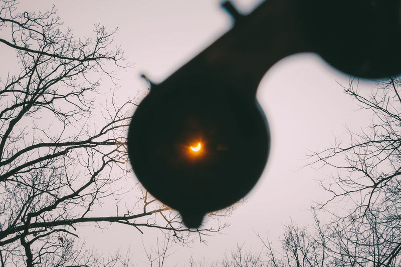 Close-up of silhouette eyewear against solar eclipse