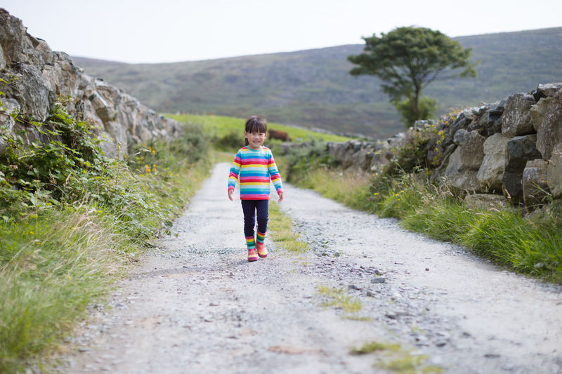 Young girl walking on summer countryside road